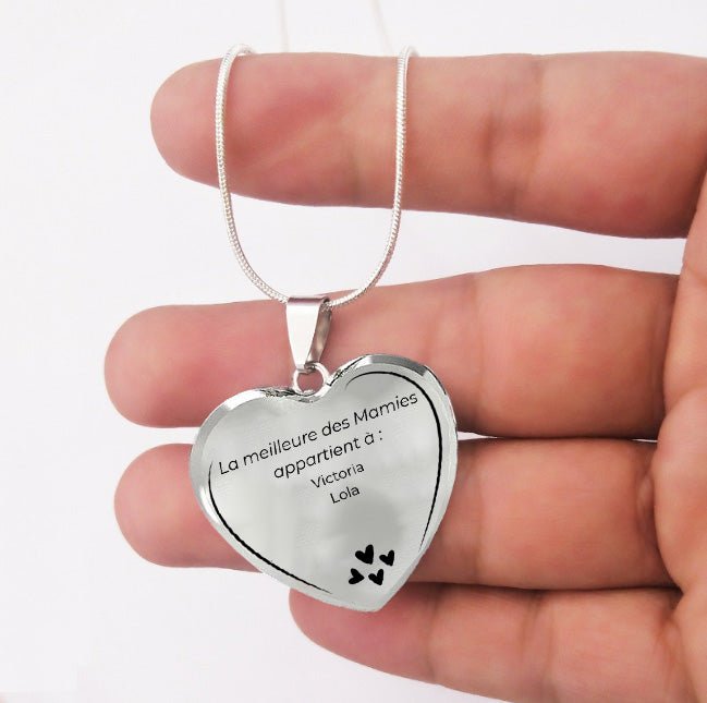 Pendentif cœur mamie gravé aux prénoms des petits-enfants, tenu au creux de la main