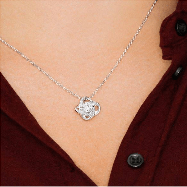 Collier trèfle porte-bonheur porté avec un chemisier bordeaux